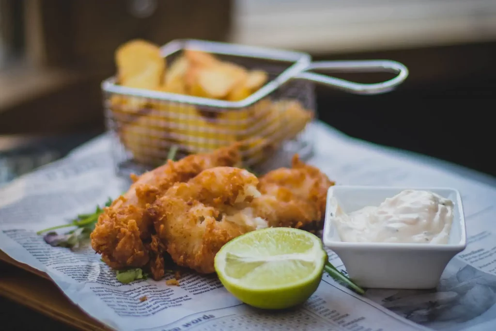A battered fish and portion of chips